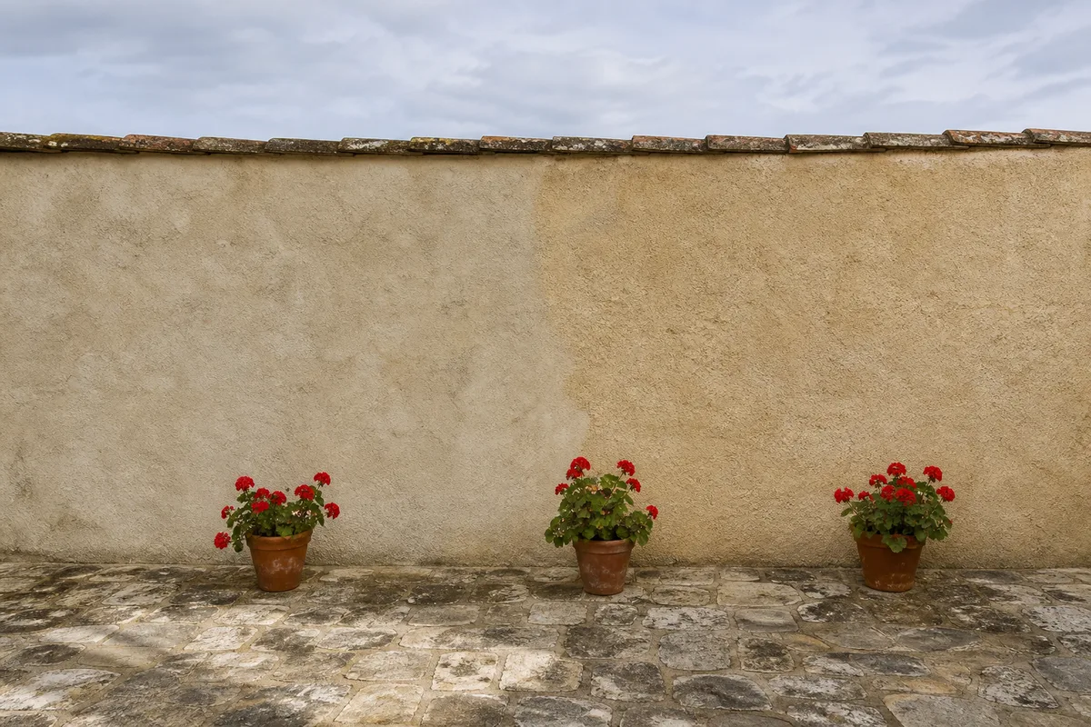 Cour intérieure d&rsquo;une maison française fermée par un mur enduit à la chaux