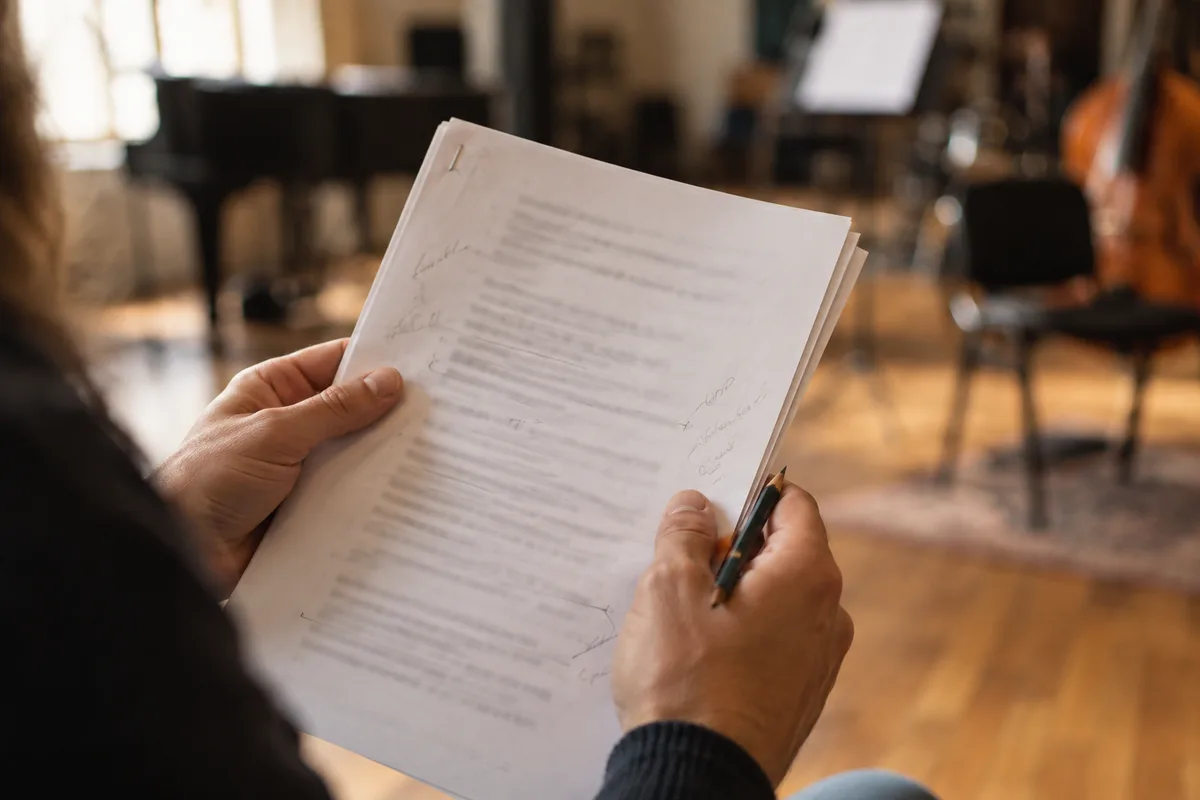Mains tenant un texte de pièce de théâtre annoté au crayon pendant une répétition